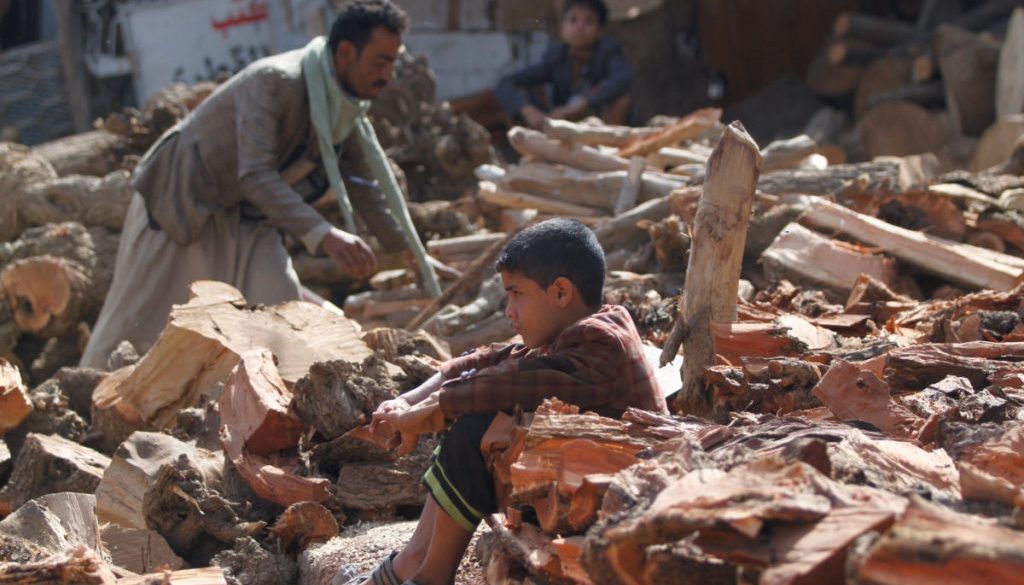 Boy sits between the wood poles at a market amid the ongoing fuel and cooking gas shortages in Sanaa